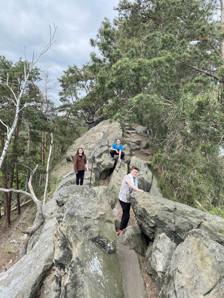 3 junge Leute klettern auf großen Felsen der spg "Teufelsmauer"