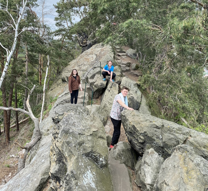 3 Junge Leute klettern auf Felsen umher