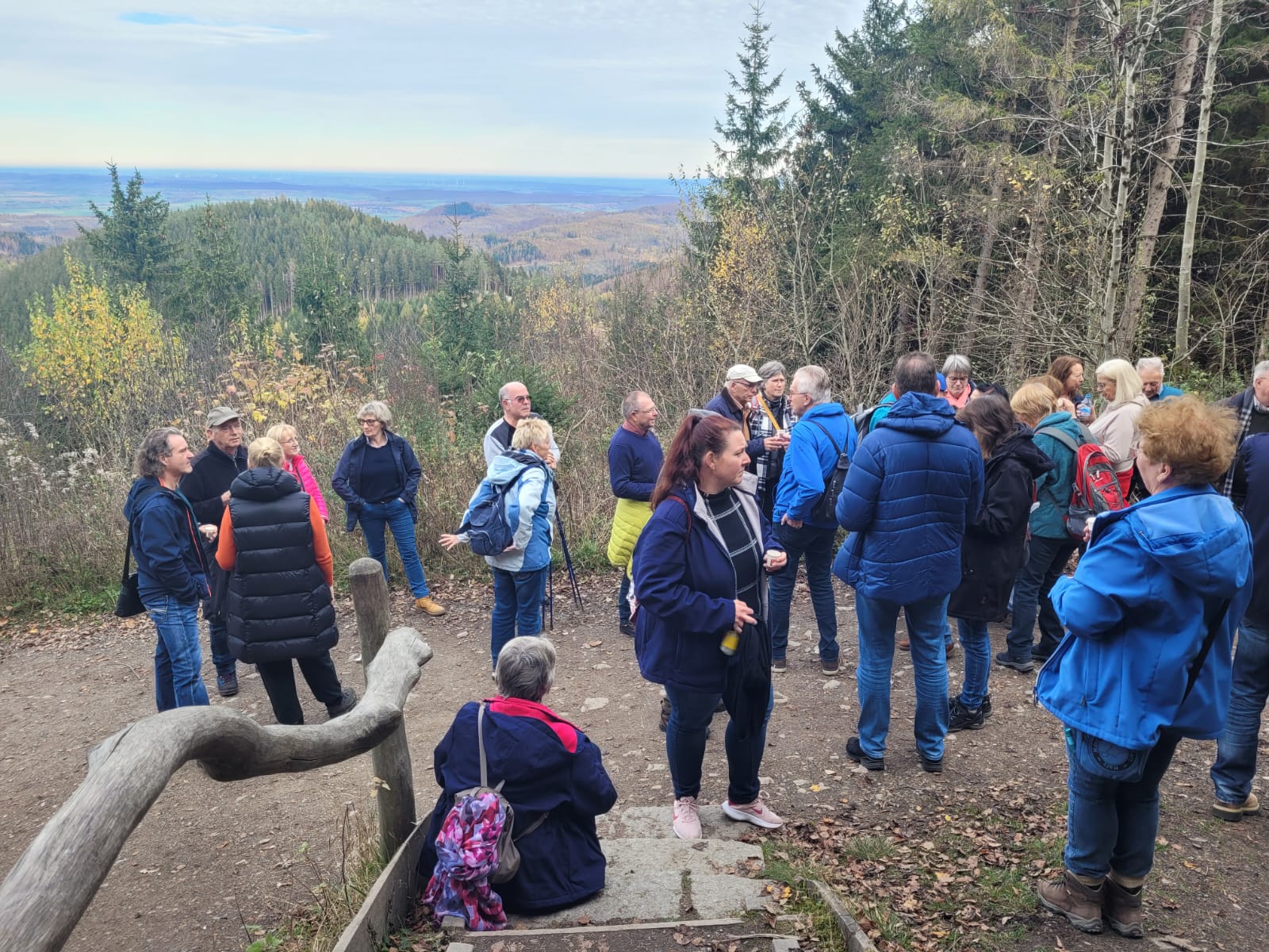 Wanderer machen eine Pause mit Blick über die Berge ins Harzvorland