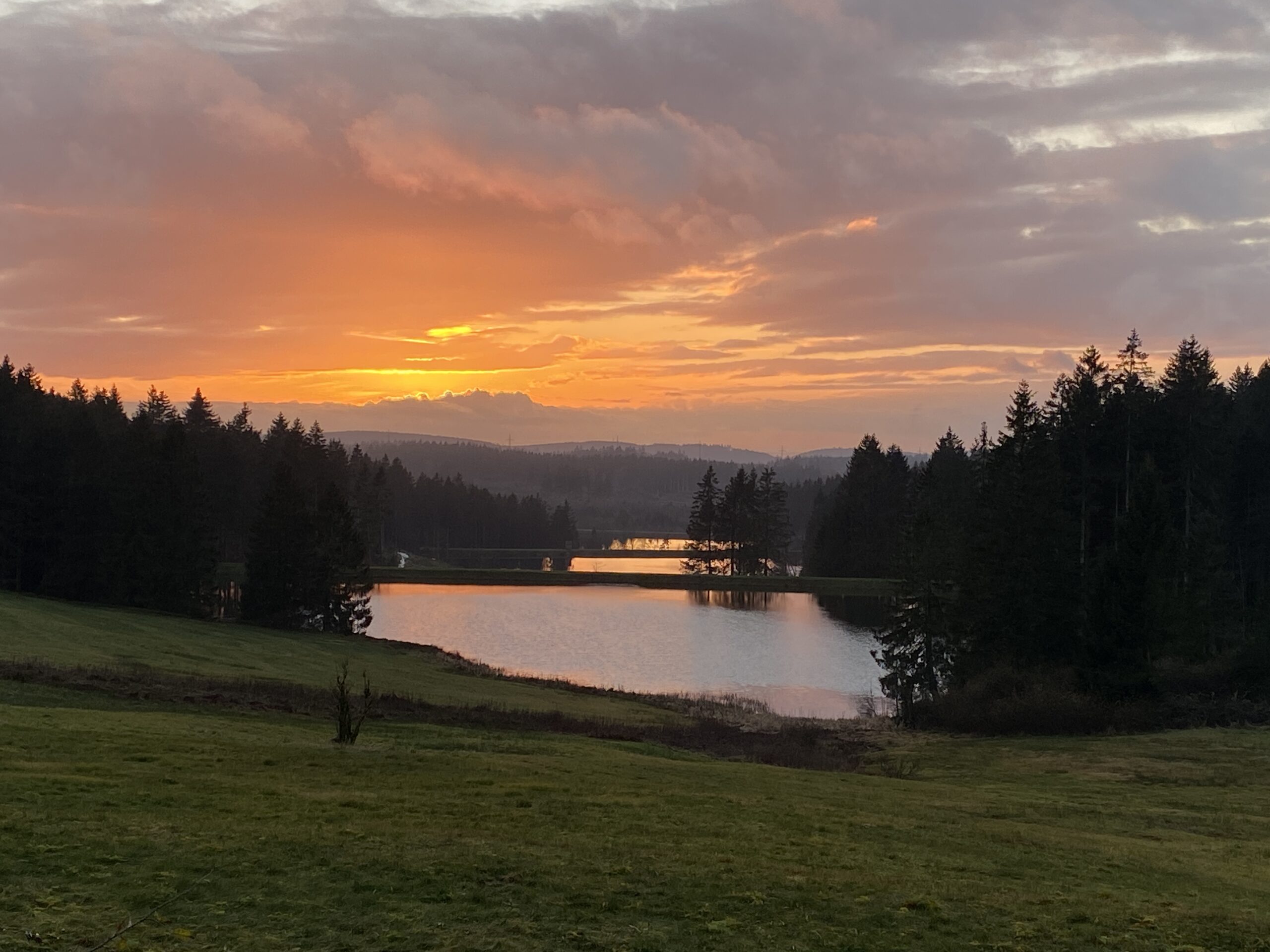 3 Teiche der Auerhahnkaskade spiegeln den Sonnenuntergang orange-rot wieder